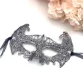 Vista dettagliata della maschera in pizzo nero e argento con motivo traforato e nastri. - Taglia unica / Argento volante