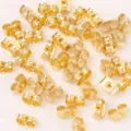 Detailaufnahme verstreuter goldener Ohrringrueckseiten, robuste Metall Ohrstopper fuer Schmuck. - 18K Vergoldet (Echtgold-Finish)