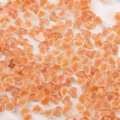 Gros plan de mini charms d'ongles cœur bonbon glacé translucide, gemmes multicolores éparpillées. - Pack de 100 / Café Translucide