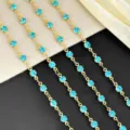 Close-up detail of 4mm gold-toned metal cup chains featuring sparkling light blue rhinestones. - Blue Gold