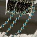 Close-up detail of blue crystal chain with gold-colored settings for DIY crafts and hair accessories. - Peacock Blue