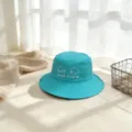 Vista detallada de un sombrero de pescador azul para niños con bordado lindo y texto divertido. - M / Azul lago