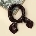 Nahaufnahme Detail eines dunkelbraunen Halstuchs aus Seidenoptik mit elegantem weißem Paisley-Muster. - #46 Kaffee-Paisley-Rand