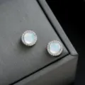 Detalle de pendientes de clip redondos iridiscentes con un halo de pedrería brillante. - Azul con Brillantes Completos