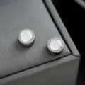 Elegantes aretes redondos tipo halo con piedras de ópalo brillantes y detalles de circonita. - Totalmente de Diamantes Blanco