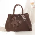 Brown leather shoulder crossbody tote bag with stylish vertical straps and cute elephant charm. - Coffee