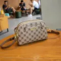 Stylish monogram crossbody bag featuring dual zippers, premium leather and adjustable strap. - Khaki