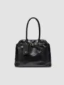 Black leather handbag detail, showing elegant shoulder strap and stylish metal hardware accents. - Black