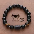 Cancer zodiac natural obsidian tiger eye bead bracelet detail view showing constellation charm. - Cancer