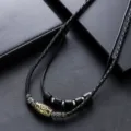 Collier vintage en perles Dzi tressées noires avec pendentifs en métal ethnique, vue détaillée. - Colliers vintage en perles Dzi bleu marine