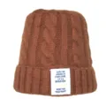 Détail de bonnet en tricot torsadé marron avec étiquette textuelle en anglais motivante. - Taille unique / Couleur caramel
