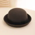 Close-up detail of the dark brown wool felt bowler hat featuring a classic black ribbon band. - Coffee
