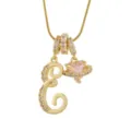 Gros plan détaillé du pendentif lettre et cœur planète doré avec des pierres zircone scintillantes. - E-Or (Chaîne Serpent)