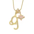 Gros plan d'un collier pendentif lettre dorée et cœur rose planète avec des zircons brillants. - G-Or (Chaîne Serpent)