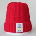 Bonnet tricoté rouge motif torsade hiver avec détail d'étiquette de texte anglais. - Taille unique / Rouge