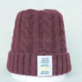 Bonnet en tricot bordeaux pour femme avec motif torsadé chaud et patch de citation inspirant. - Taille unique / Rouge Cuir