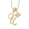 Gros plan détaillé d'un collier pendentif lettre plaqué or avec un charm cœur saturne rose étincelant. - U-Or (Chaîne Serpent)