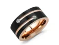 Close-up detail of men's black brushed stainless steel ring with rose gold groove and dual cubic zirconia. - Black & Rose Gold