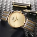 Primo piano dettagliato di orologio da donna al quarzo con quadrante dorato e cinturino. - oro bicolore