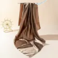 Detailed view of elegant brown satin square scarf draped gracefully on display hook. - 90cm X 90cm / Coffee Brown