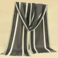 Detail view of stylish men's striped knitted scarf with cozy tassels for winter outdoor warmth. - Medium Grey