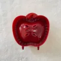 Red apple hand pie mold detail view, showing textured edges and air vent design for baking. - Apple