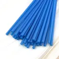 Primo piano dettagliato di cannucce di plastica blu in fascio su sfondo in legno chiaro. - Blu scuro