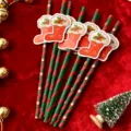 Christmas decorative paper straws detail view with cute stocking cutouts and festive props. - Santa Claus Straws with Red Stocking