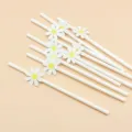 Close up detail of white paper drinking straws decorated with cute yellow and white daisy flowers. - Small White Flower & White Straws