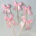 Pink satin ribbon bow cake toppers detail view, cute dessert decoration picks for party baking. - Pink