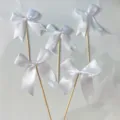 White satin ribbon bow cake toppers with wooden sticks for birthday party baking dessert decorations. - White