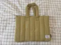 Quilted laptop bag detail showing fabric texture, sturdy handles, and branded woven tag. - Custom Edition Matcha Green