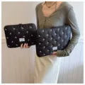 Detailed view of black quilted laptop sleeve with cute white bow embroidery and zipper. - 11" / Black