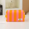 Dettaglio borsa trucco in spugna a righe rosa e arancione, astuccio cosmetico portatile. - Strisce arancioni e viola