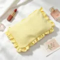 Closeup detail of the cute yellow striped cosmetic pouch with delicate ruffles and zipper. - Yellow