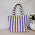 Detailed view of the purple and yellow striped canvas tote bag, showing fabric texture and strap. - Purple-Yellow