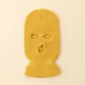 Primer plano de pasamontañas de punto amarillo con tres agujeros, detalle de invierno. - Amarillo