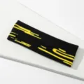 Cinta de pelo deportiva de punto negro con diseño amarillo, ideal para fitness y yoga. - Líneas Negras