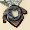 Detaillierte Ansicht des stilvollen Hahnentritt-Seidenschals mit elegantem orangen Rand. - #32 Schwarzes Hahnentrittmuster mit orangem Rand 60