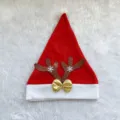 Detail view of plush Christmas Santa hat featuring glitter reindeer antlers and gold bow. - Purple Antler Christmas Hats
