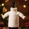 Gedetailleerde opname van witte pluche gebreide wijnfleshoes voor feestelijke kersttafeldecoratie - Witte Gebreide Wijnflessenhoes
