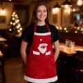 Grembiule natalizio rosso festivo con simpatico design del viso di Babbo Natale per festa. - Grembiule da Babbo Natale rosso