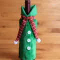 Kerst fleshoes detail, groene fleskleding met gebreide sjaal voor feestelijke tafeldecoratie. - Wijnfleshoezen met rode sjaal