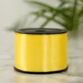 Detailed view of a yellow plastic balloon ribbon roll, perfect for gift wrapping and party decor. - Yellow