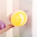 Gros plan d'un ballon en agate jaune de 10 pouces montrant son motif marbré unique. - Jaune