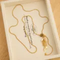 Gold-tone fish skeleton pendant necklace with natural stone accent, chic long sweater chain. - Fishbone Pull-out Necklace / Gold