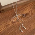 Silver tone long bowknot necklace with delicate drop pendants, elegant sweater chain jewelry. - Bowknot Pull-out Necklace