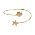 Brazalete abierto de metal dorado con dijes de concha y estrella de mar para verano. - Dorado