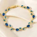 Close-up detail of the gold vine bracelet featuring sparkling blue cubic zirconia leaf stones. - Blue Main Stone Branch Gold (TS0471)