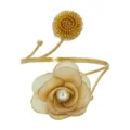 Nahaufnahme Detailaufnahme des goldenen Drahtblumen und Stoffperlen offenen Armreifs. - Kamellienblüte in Braun